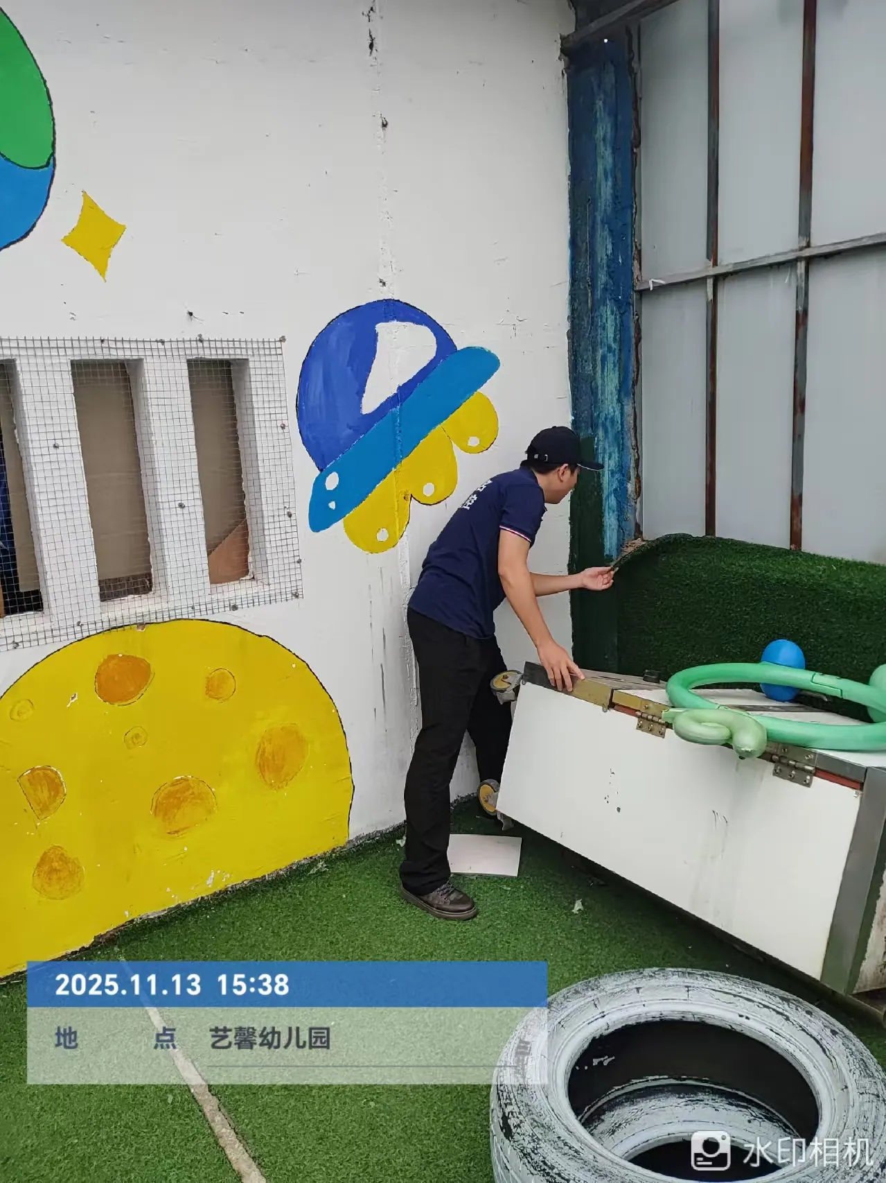 工作人员检查幼儿园户外墙边设施