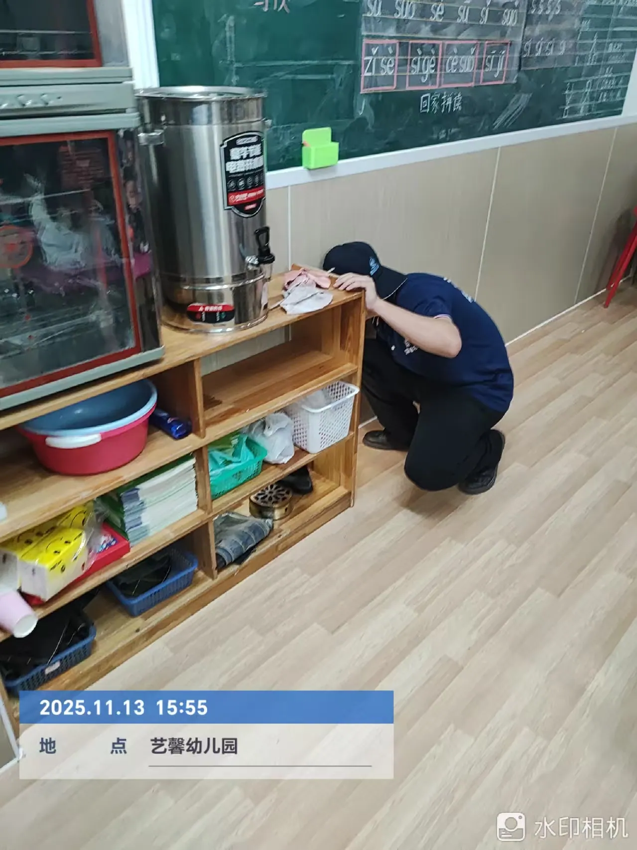工作人员检查幼儿园教室柜体下方