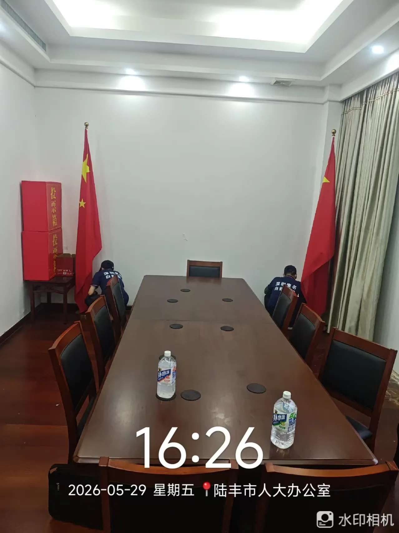 工作人员检查办公会议空间墙边位置