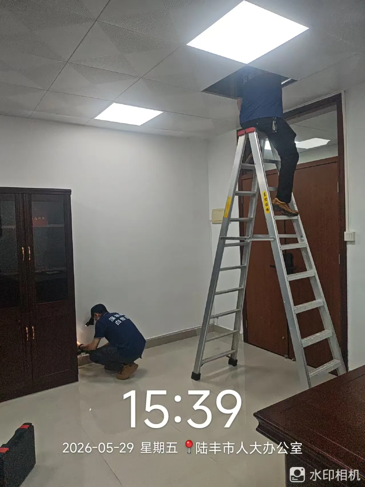 工作人员使用梯具检查办公室吊顶
