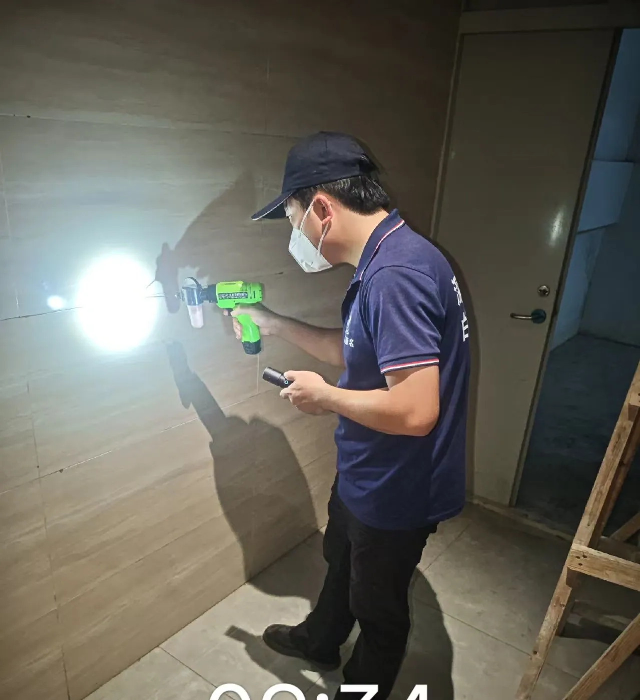 工作人员使用照明工具检查住宅墙面